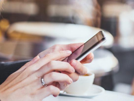 photo of woman hands holding smartphone in cafe picture-id875258198